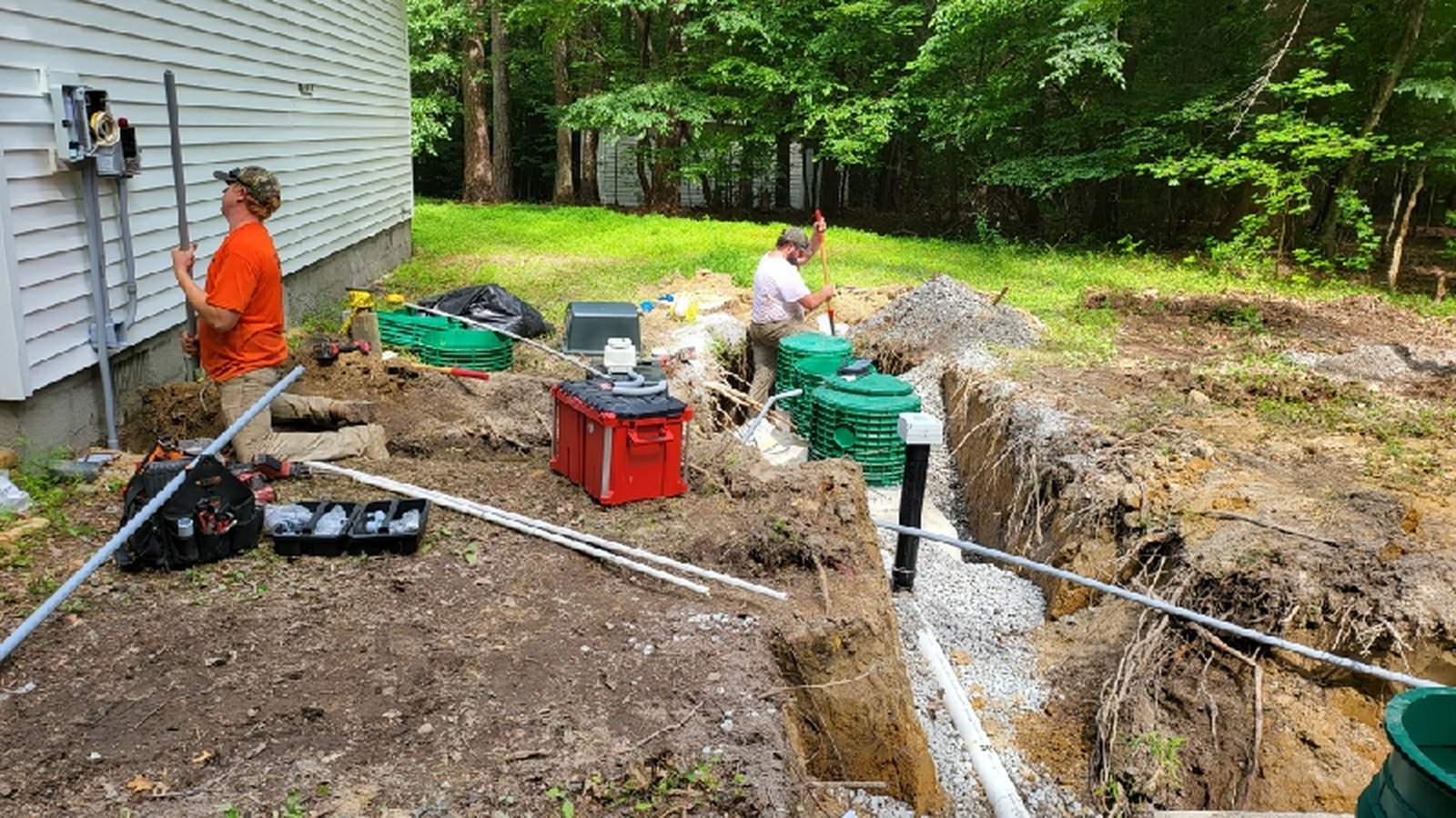 Construction site with workers digging trenches and equipment