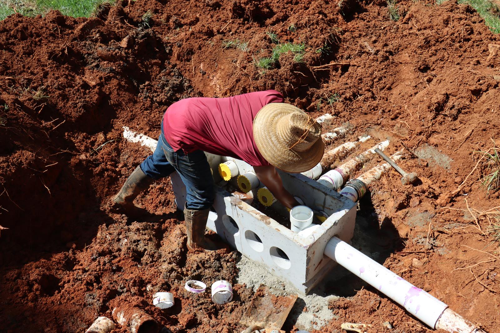 Digging a septic system in red soil with pipes and manufacturing