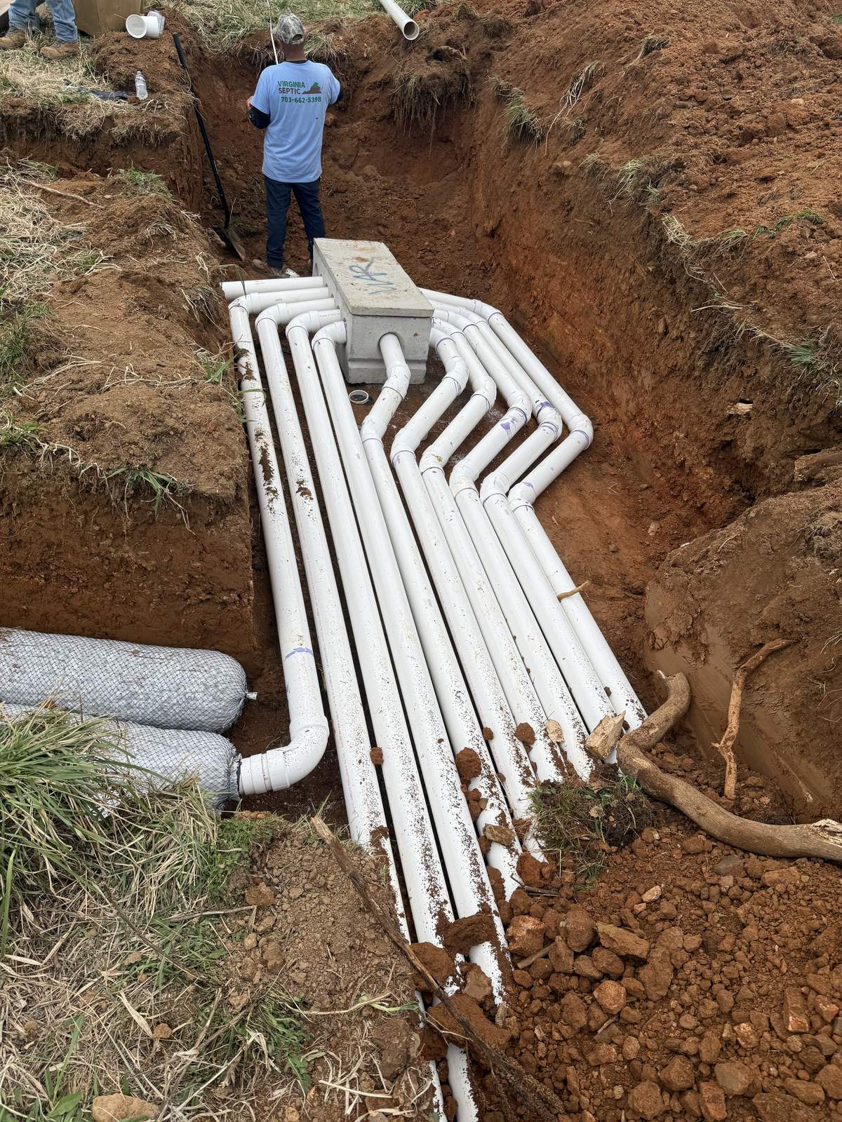 Septic pipe installation in digging site with worker