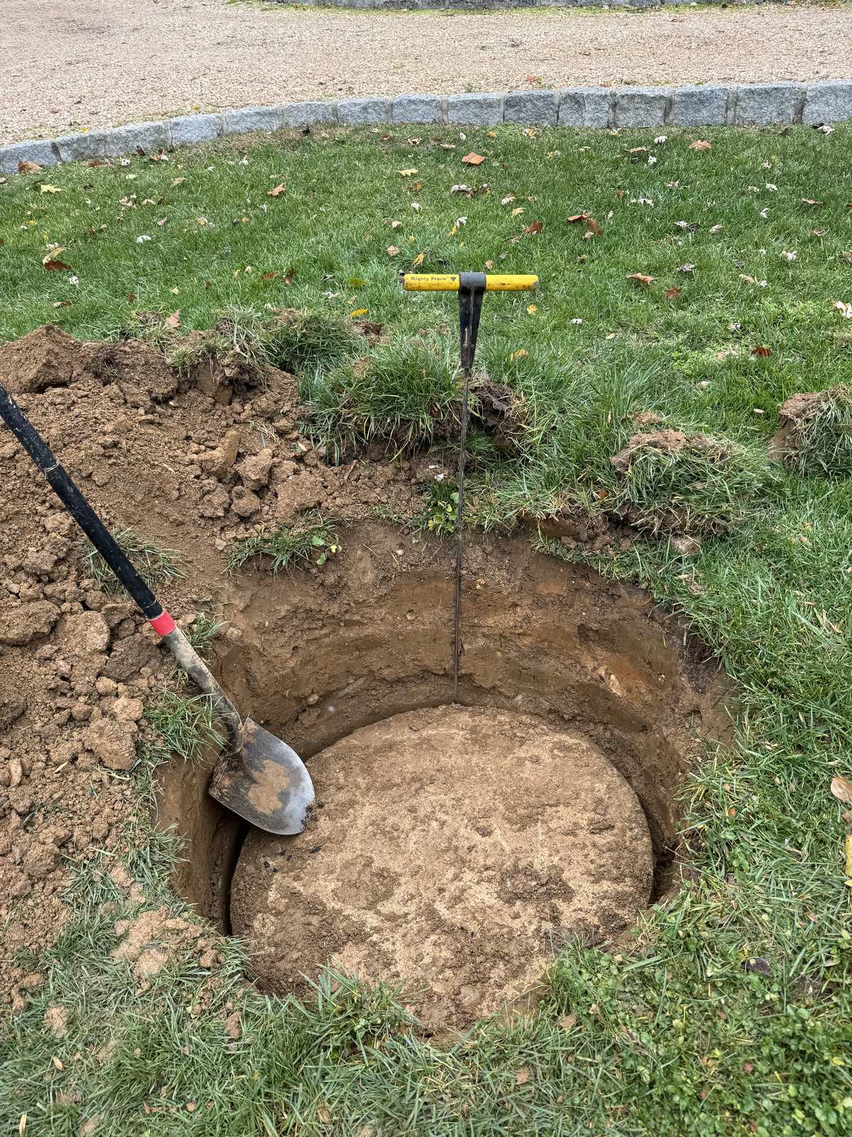 Digging out a septic tank access hole for cleaning near Manassas