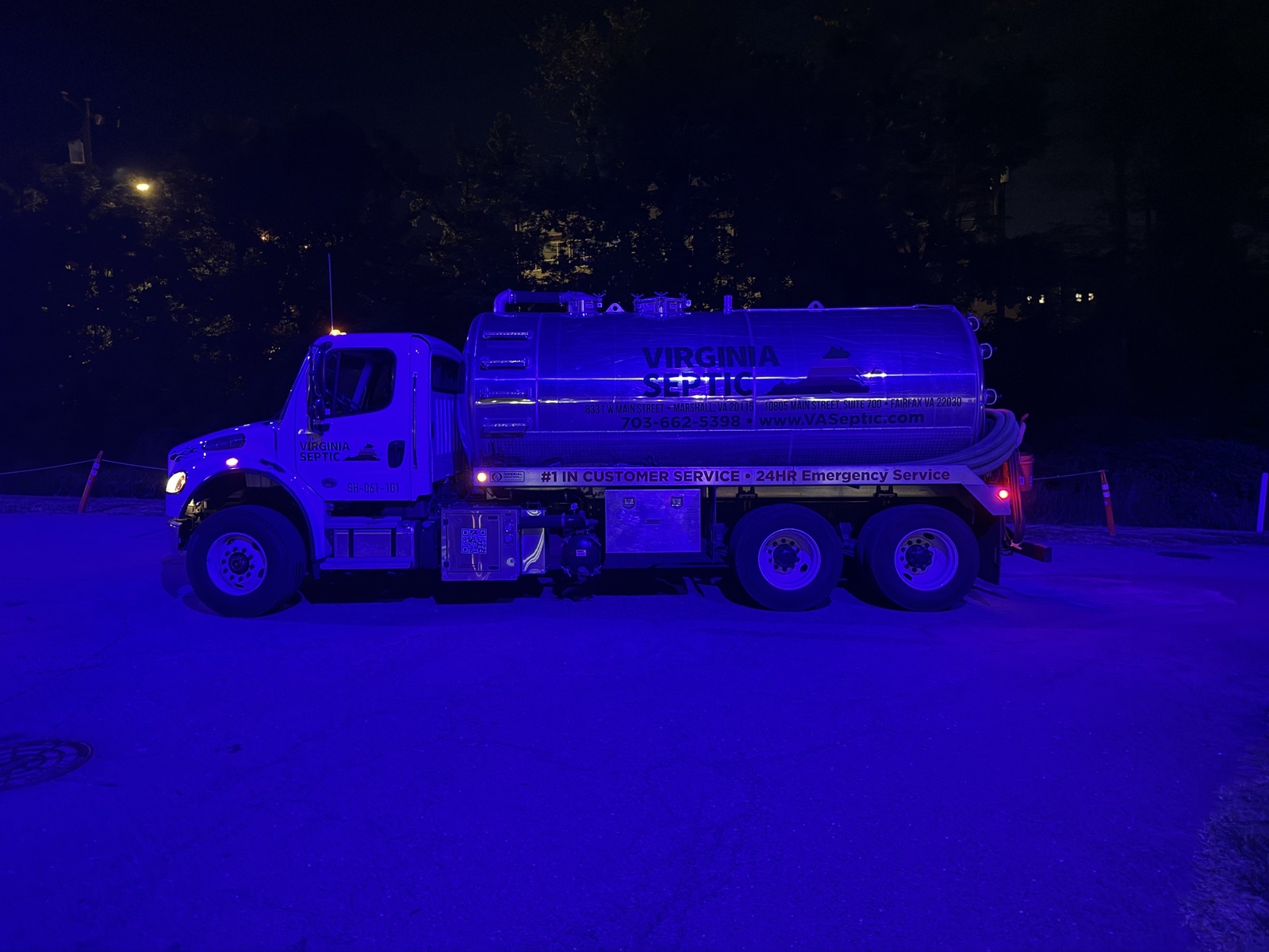 Virginia Septic truck at night with blue lights illuminating