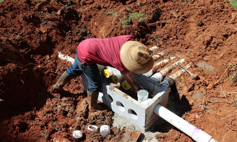 Digging a septic system in red soil with pipes and manufacturing