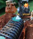 Workers installing a septic system at a Hartfield area site